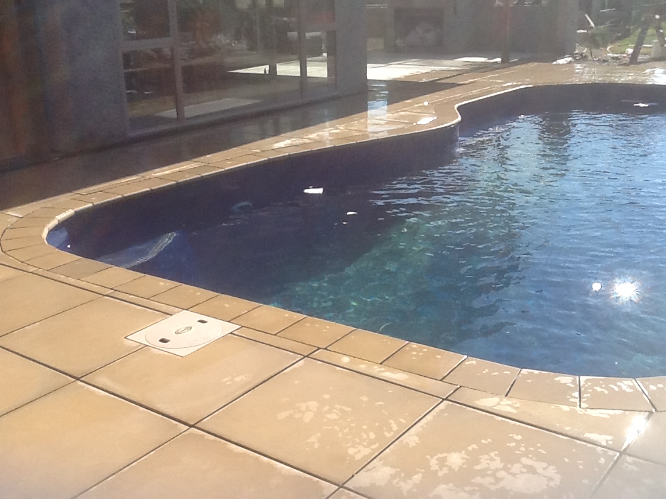 Pool paving completed around a curved swimming pool